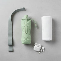Overhead flat lay photo of Foldo sage green foldable water bottle